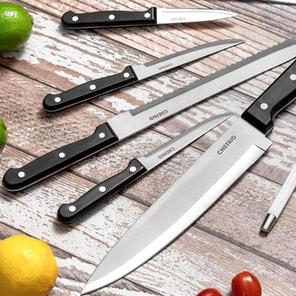 Chef Aid paring knife displayed with stainless steel kitchen knives and black riveted handles on a rustic wooden surface.
