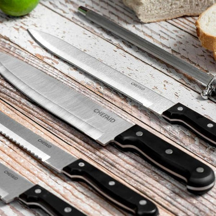 Chef Aid stainless steel paring knife among assorted kitchen knives with black riveted handles and a honing steel on rustic wood.