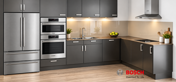 Modern Bosch kitchen featuring stainless steel home appliances, including a French door refrigerator, built in ovens, extractor hood and electric cooktop, styled with dark grey cabinetry, warm lighting and contemporary kitchen accessories. Bosch “Invented for life” branding is displayed at the bottom.