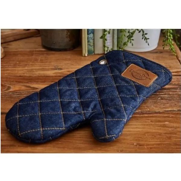 Oxford Denim single oven glove in quilted dark blue denim with brown leather-look brand patch, displayed on a wooden worktop.