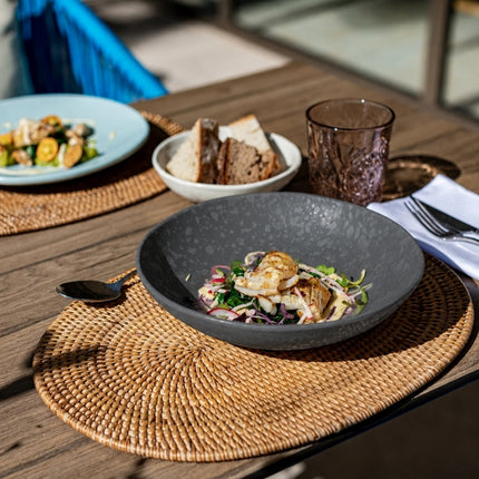 Dalebrook Mineral Agate grey melamine dish serving grilled seafood and salad on a woven placemat at a restaurant table.