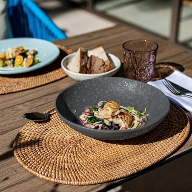 Dalebrook Mineral Agate grey melamine dish serving grilled seafood and salad on a woven placemat at a restaurant table.