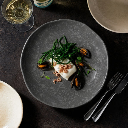 Overhead view of white fish, mussels and green vegetables served on a Dalebrook Mineral Agate grey crackle-finish plate.