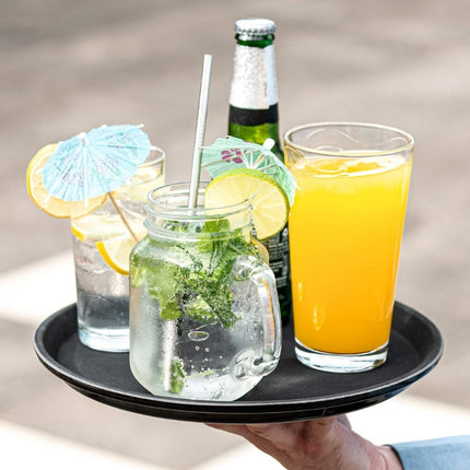 Grunwerg Tuffgrip round serving tray being carried with chilled water, a citrus drink, orange juice and a bottle.
