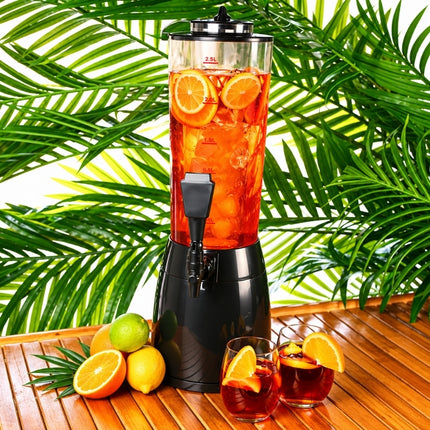Ice-core beverage dispenser filled with red citrus punch, ice and orange slices, served with two garnished glasses.