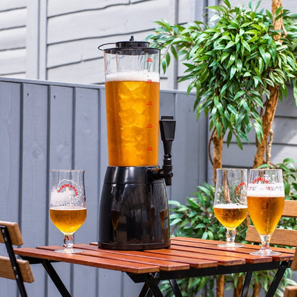 Ice-core beverage dispenser filled with beer and central ice tube, displayed outdoors with three beer glasses.