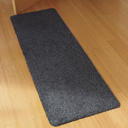 Dark grey JVL Tanami barrier runner laid on a wooden hallway floor beside a doorway.