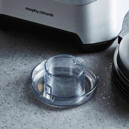 Clear removable lid cap beside the Morphy Richards blender base and black jug lid.