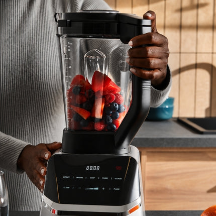 Morphy Richards blender jug filled with strawberries, raspberries and blueberries above the illuminated multifunction control panel.
