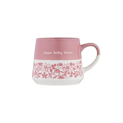 A pink and white ceramic mug with a floral pattern band and the text 'bloom baby, bloom' on the side, shown against a plain white background.