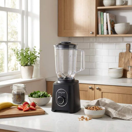 Black blender on a kitchen counter with ingredients and a window in the background