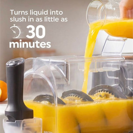 A countertop juicer filled with orange juice, with more orange liquid being poured into it from a glass container. White text on the left reads, 'Turns liquid into slush in as little as 30 minutes.