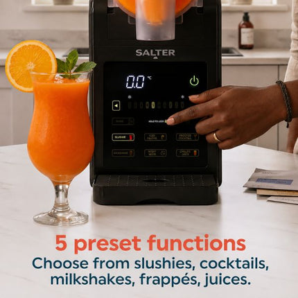 A Salter countertop beverage dispenser in black, shown with an orange drink in a glass and a person's hand pressing the control panel. Text at the bottom reads '5 preset functions' and 'Choose from slushies, cocktails, milkshakes, frapps, juices.
