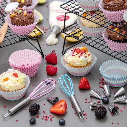 Decorated cupcakes displayed on black Tala tiered cooling racks with berries, cupcake cases and baking tools