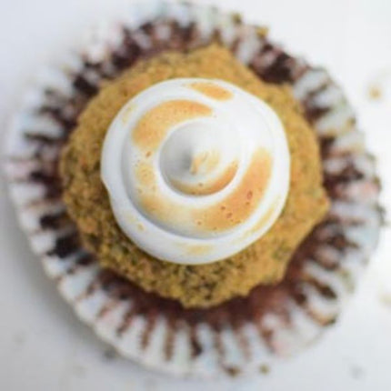 Cupcake with white frosting and a yellow center on a white background