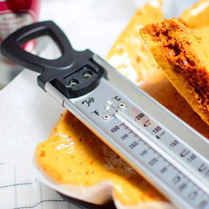 Close-up of a Tala jam thermometer with black loop handle and Celsius and Fahrenheit scales beside golden honeycomb candy