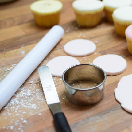 Tala small angled palette knife beside a rolling pin, round cutter and pink fondant circles for decorating cupcakes