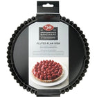 Fluted flan dish with packaging featuring a pie with berries on a white background