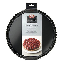 A black fluted round tart pan in its retail packaging, featuring a hanging cardboard header with the Tala brand logo and a label identifying it as a fluted flan dish.