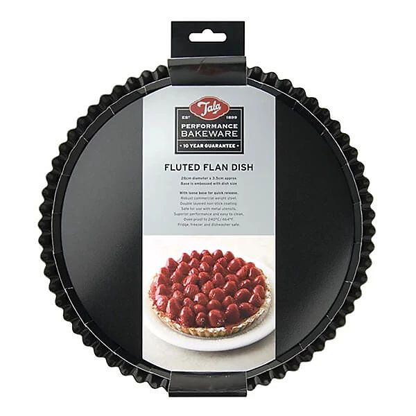 A black fluted round tart pan in its retail packaging, featuring a hanging cardboard header with the Tala brand logo and a label identifying it as a fluted flan dish.