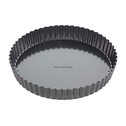 A round fluted tart pan with a dark gray non-stick interior and a black exterior, shown from a top-down angle on a white background.