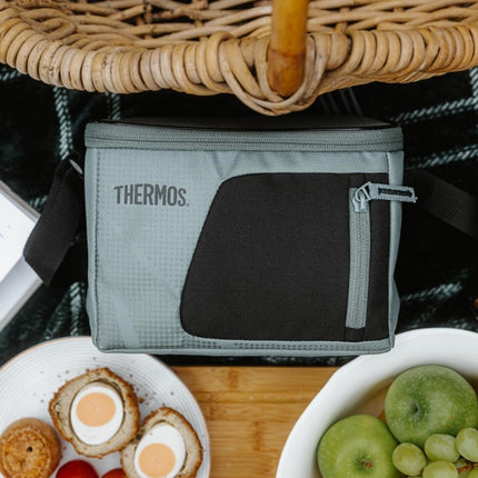 Thermos Radiance 4.5L cooler bag beside a picnic wicker basket, eggs, apples and grapes.